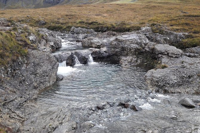 The Fairy Pools in the Isle of Skye are a mesmerizing oasis of crystal-clear waters, nestled amidst verdant hills and cascading waterfalls, where the ethereal beauty of the landscape transports visitors to a realm of enchantment and tranquility.